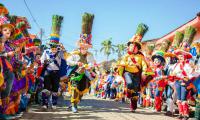 A group of people wearing the typical mask of the Diriamba culture, the Güegüense, accompany San Sebastián.