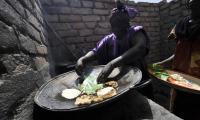 Chad. A woman making cassava bread on a grill. This is just one of the many food products made from the cassava plant. © FAO/Sia Kambou