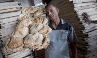 Egypt. A baker showing traditional "baladi" bread fresh from the oven at a bakery in the Giza district of Cairo.  © FAO/Giulio Napolitano